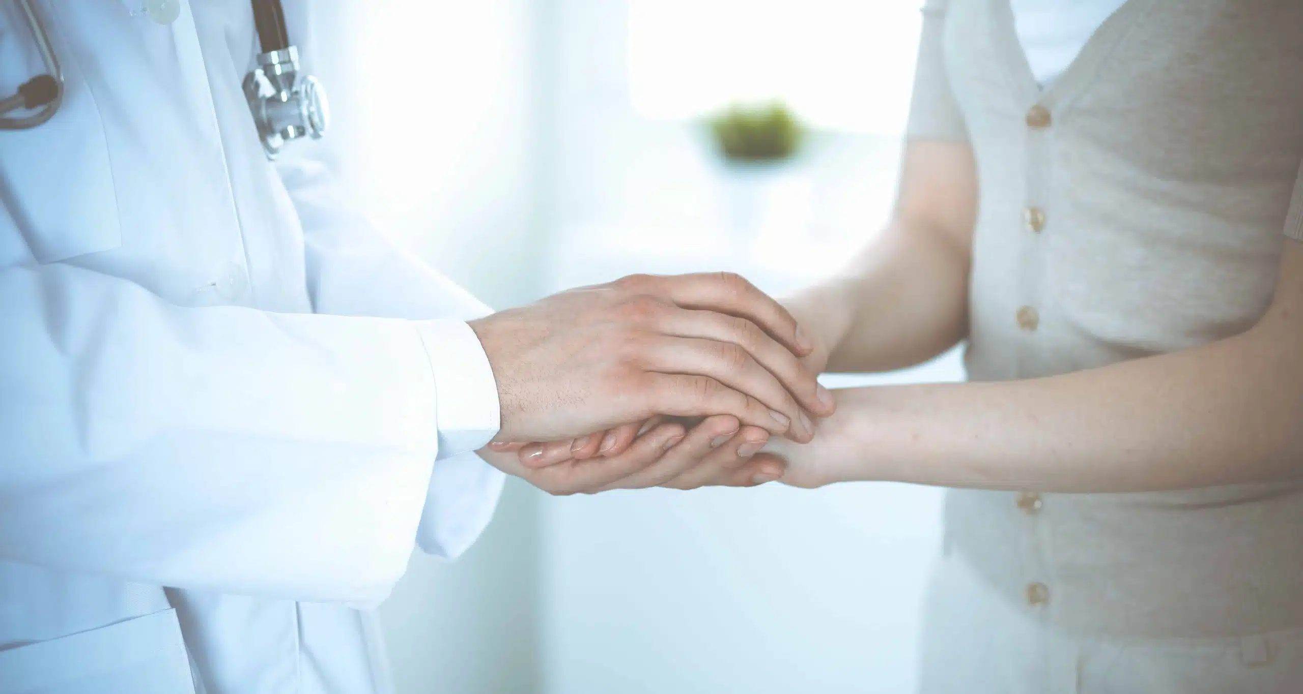 Hand of doctor reassuring her female patient. Medicine and health care concept