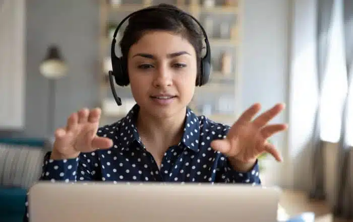 Indian young business woman student teacher tutor wear wireless headset video conference calling on laptop computer talk by webcam learn teach in online chat, distance webinar online teaching concept