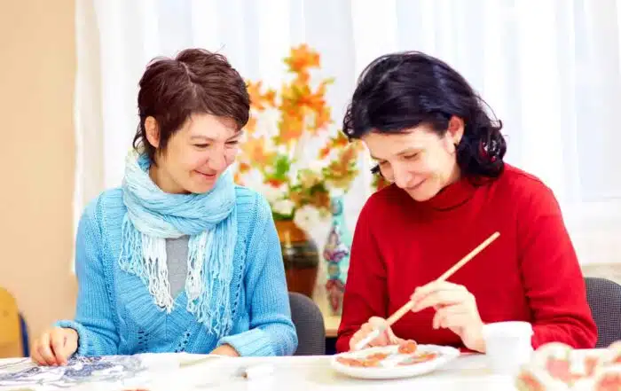 adult women handcrafting plates
