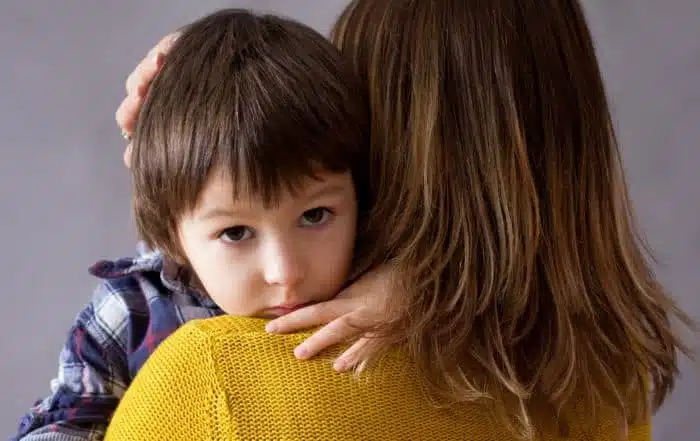Sad little child is hugging his mother