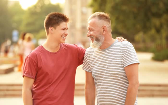 Teenager boy with grandfather in park