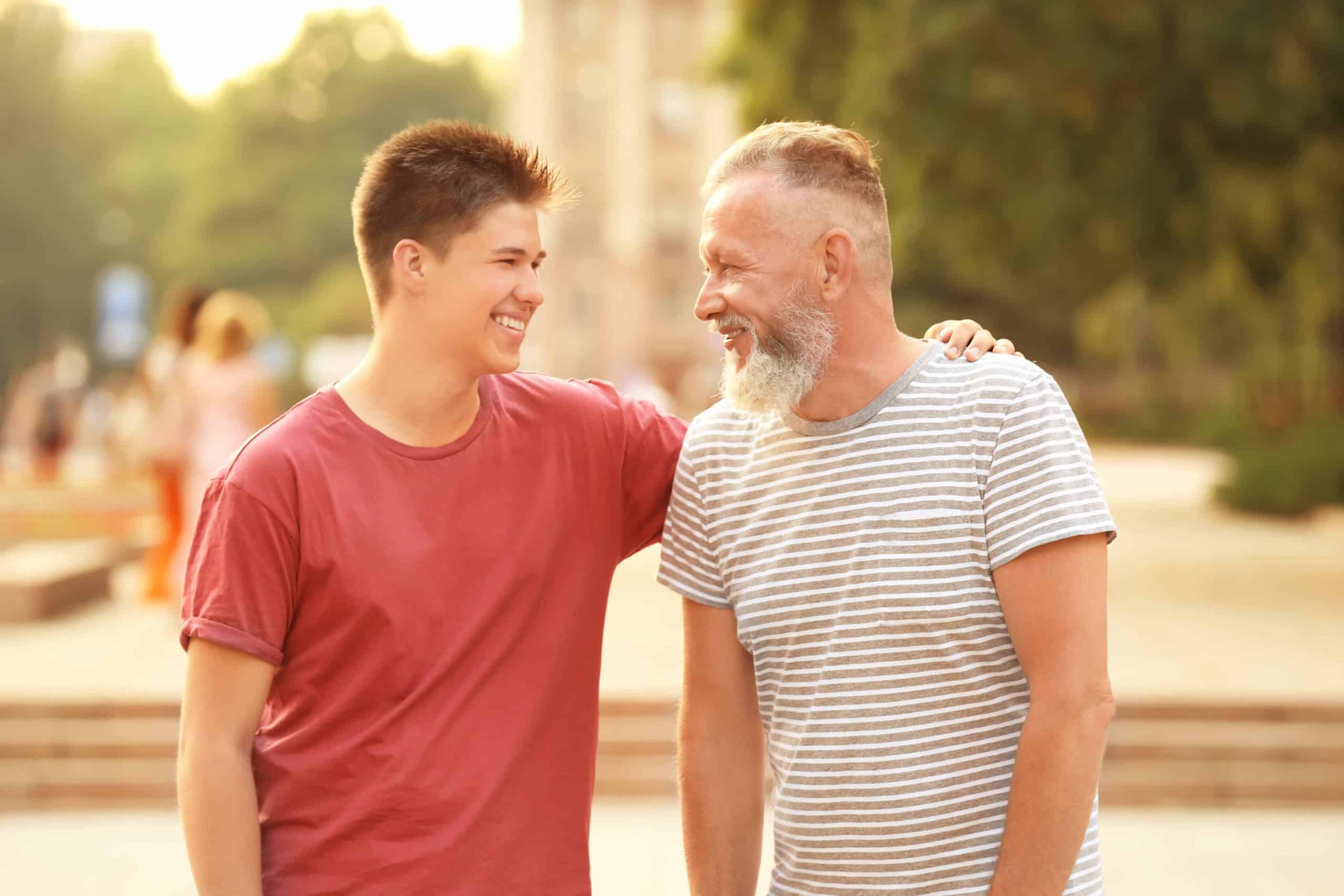 Teenager boy with grandfather in park
