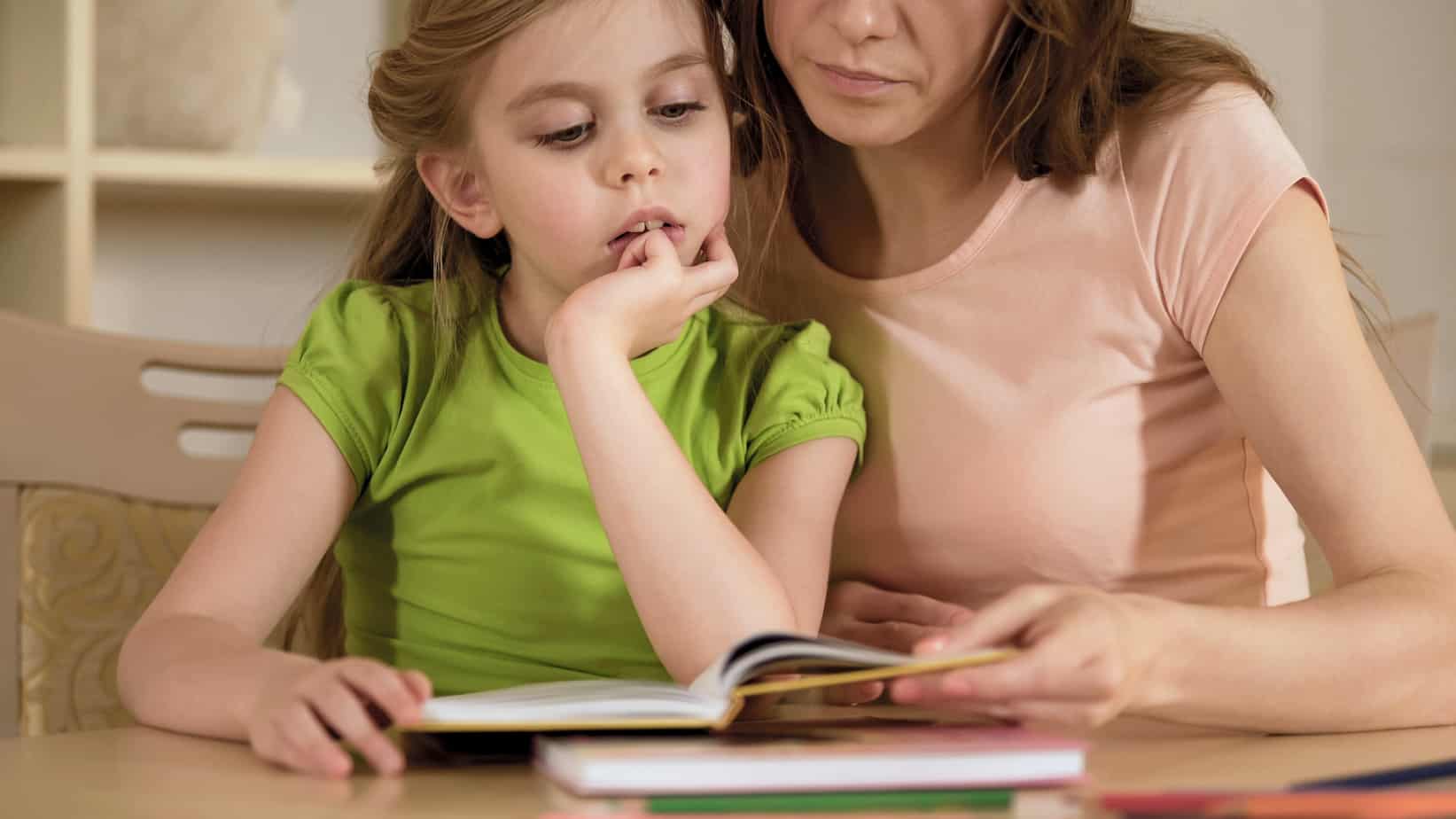 Mom and daughter reading books together