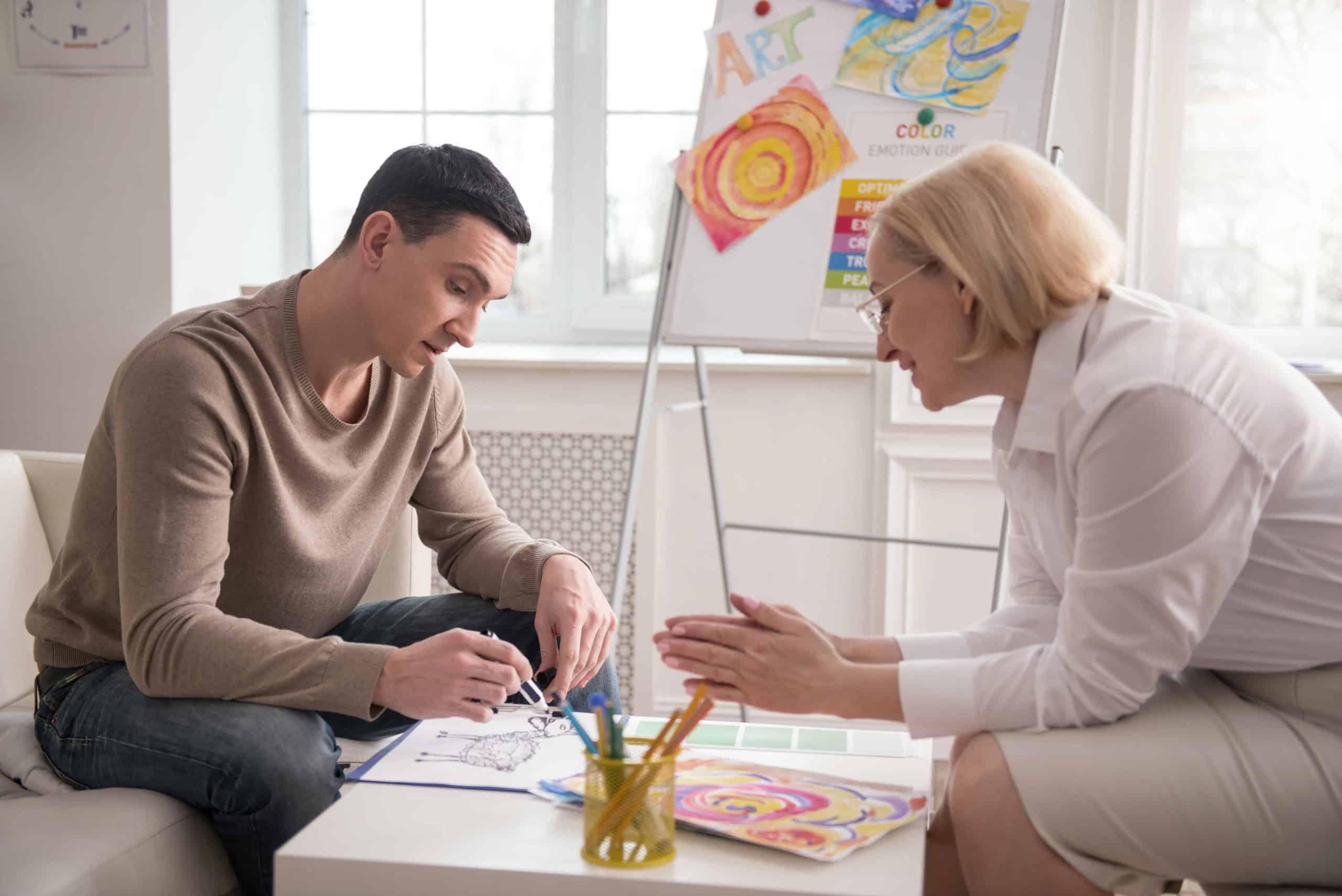 psychologist sharing her observation while man drawing
