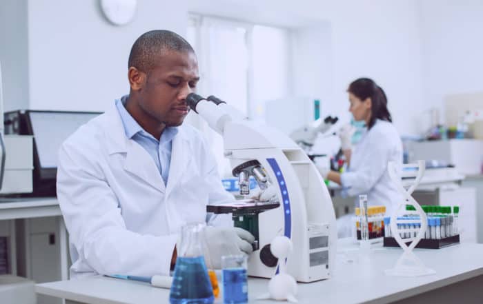 Serious male researcher working with his microscope