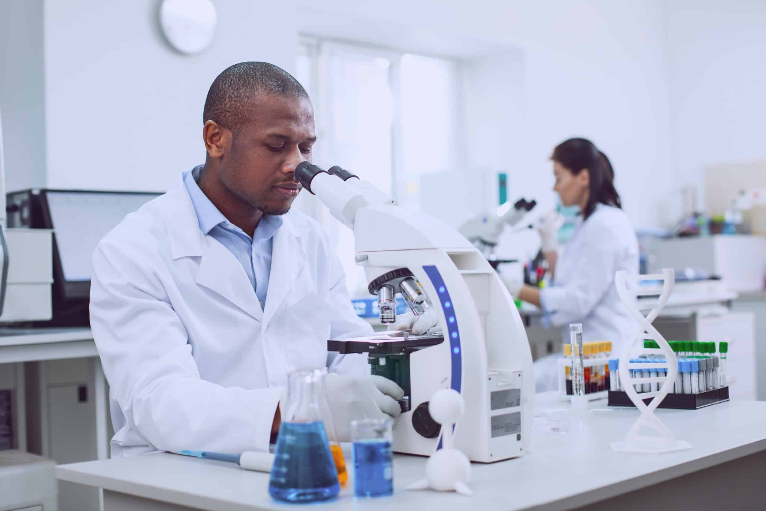 Serious male researcher working with his microscope Gene Penetrance