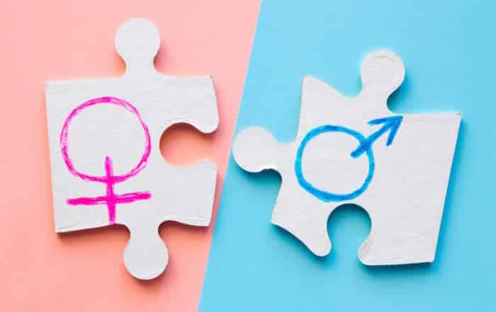 puzzle pieces with male and female gender symbols on the pink and blue background. concept equality
