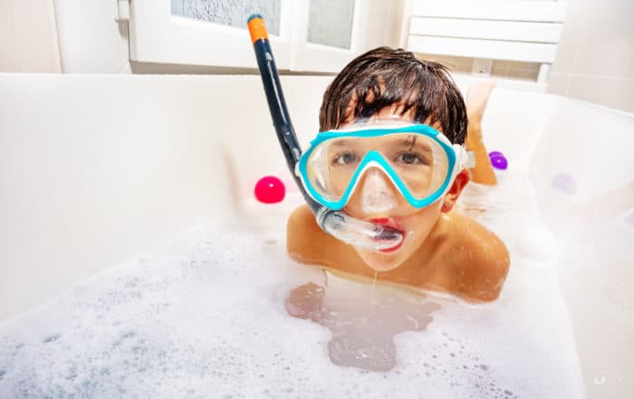 Little cute boy swim and dive in the bathtub wear snorkeling mask, scuba smiling play with soap waiting sea summer vacations