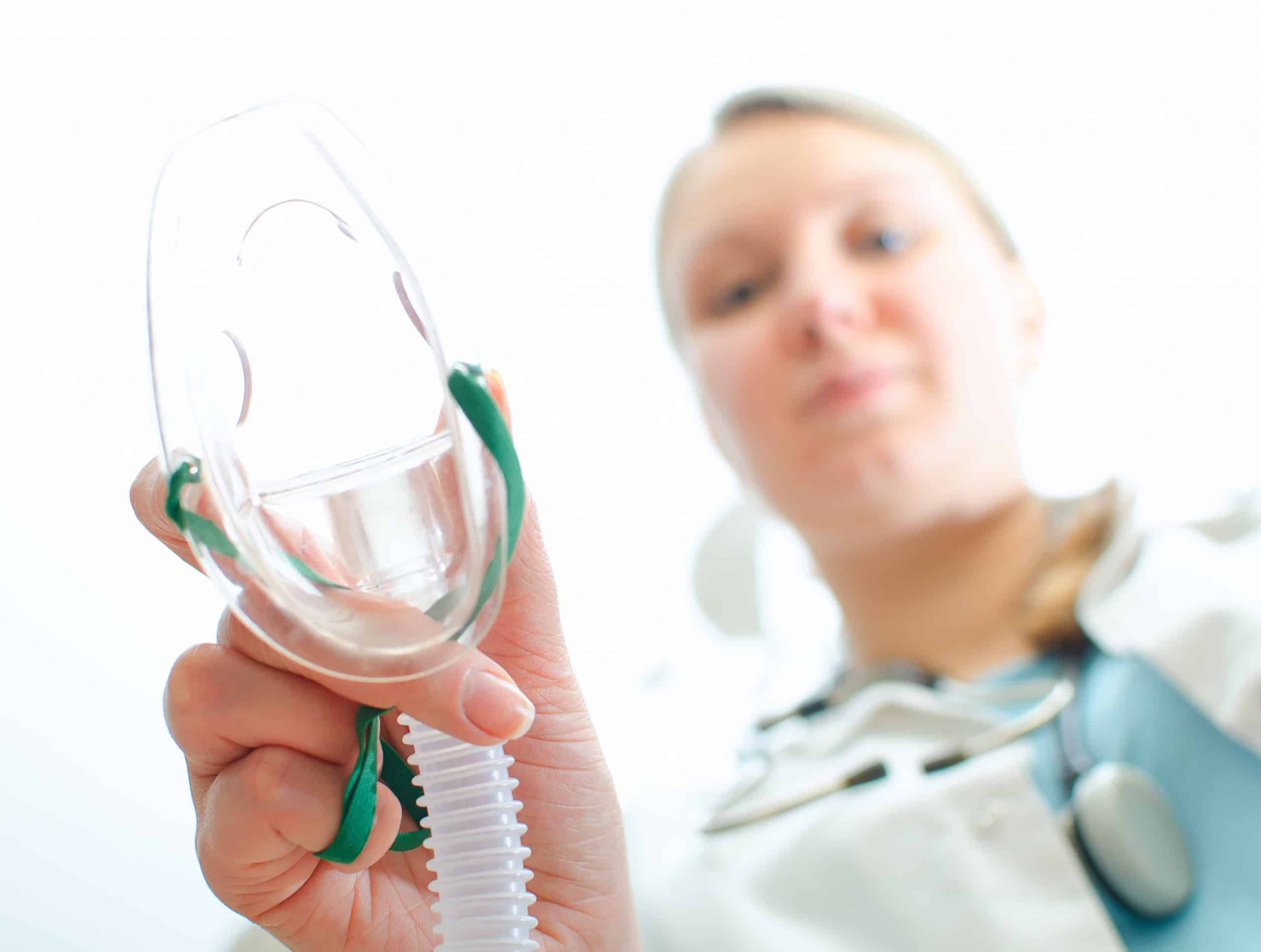 Female assisitant giving gas mask to patient Female assisitant giving gas mask to patient
