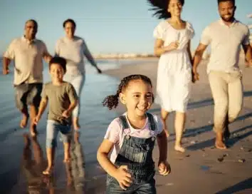 Parents and children running along the shore of a beach