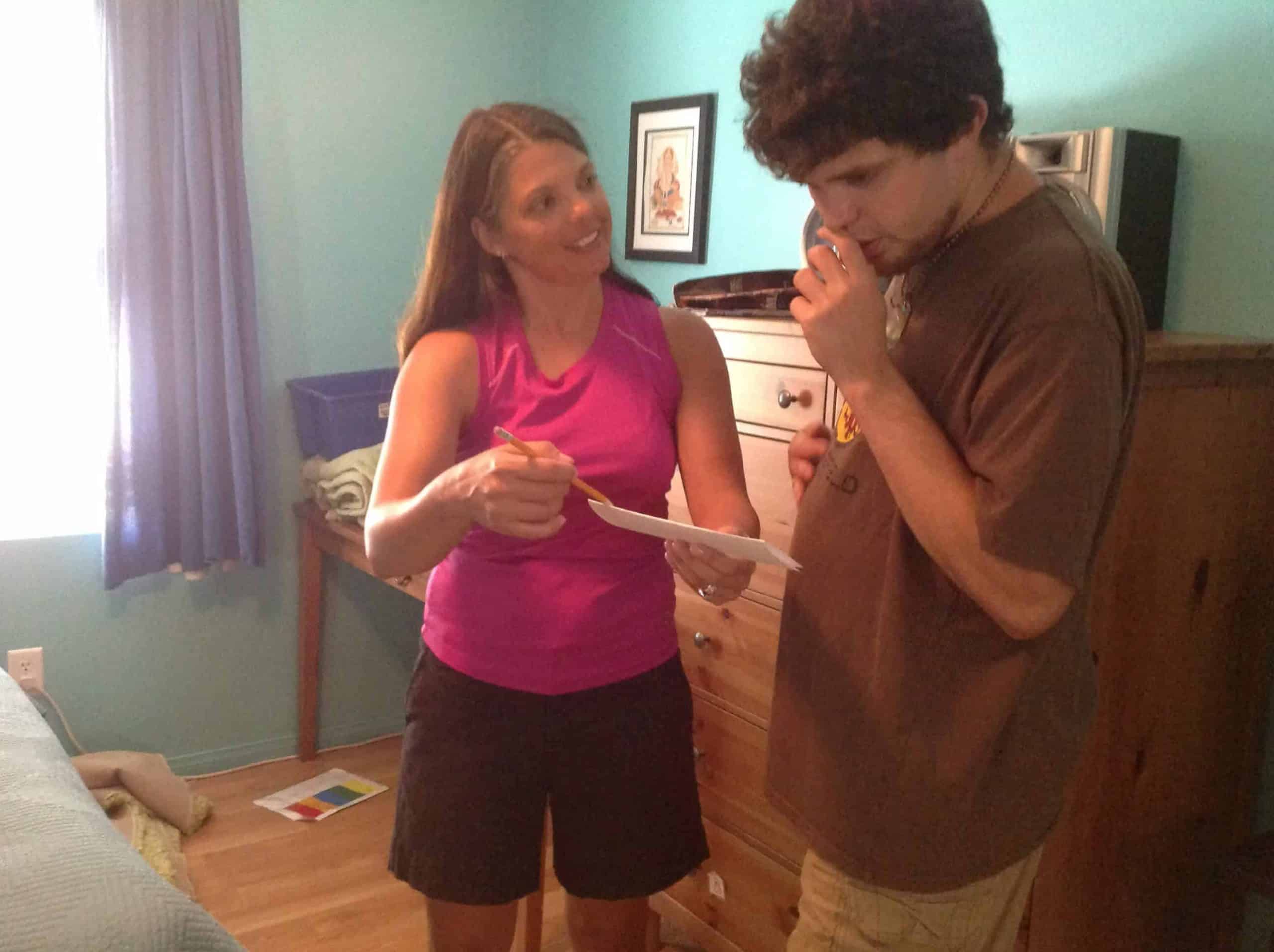 Woman guiding an autistic boy by showing writing