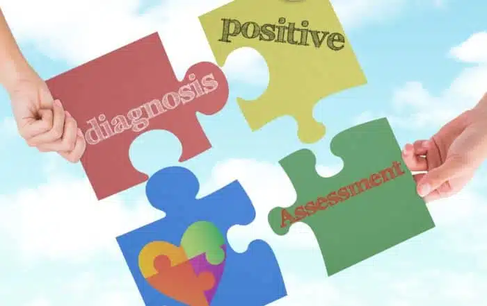 People holding up puzzle pieces with different words written on them