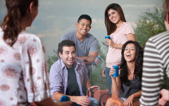 Group of six happy young people socialize outside