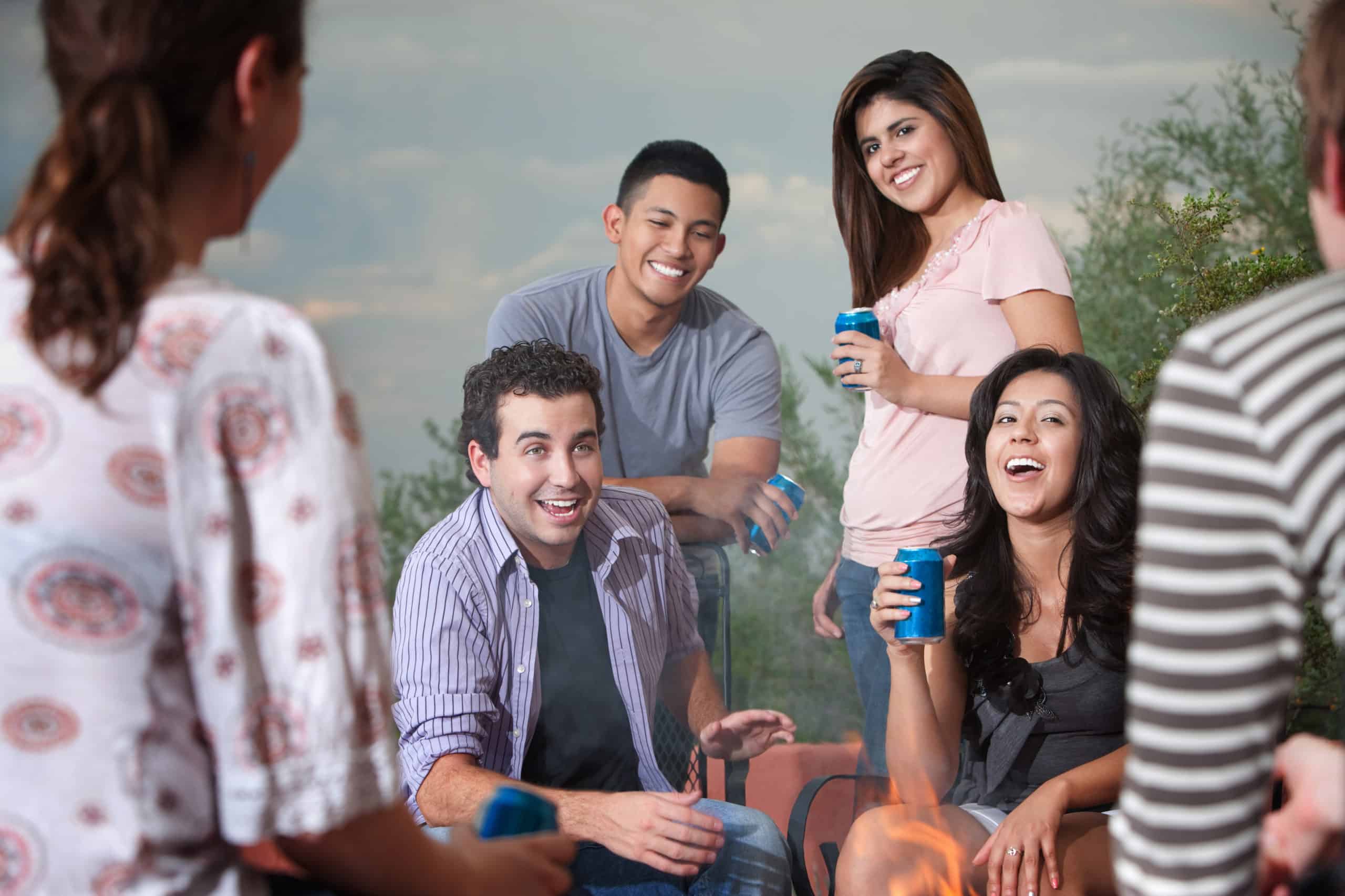 Group of six happy young people socialize outside