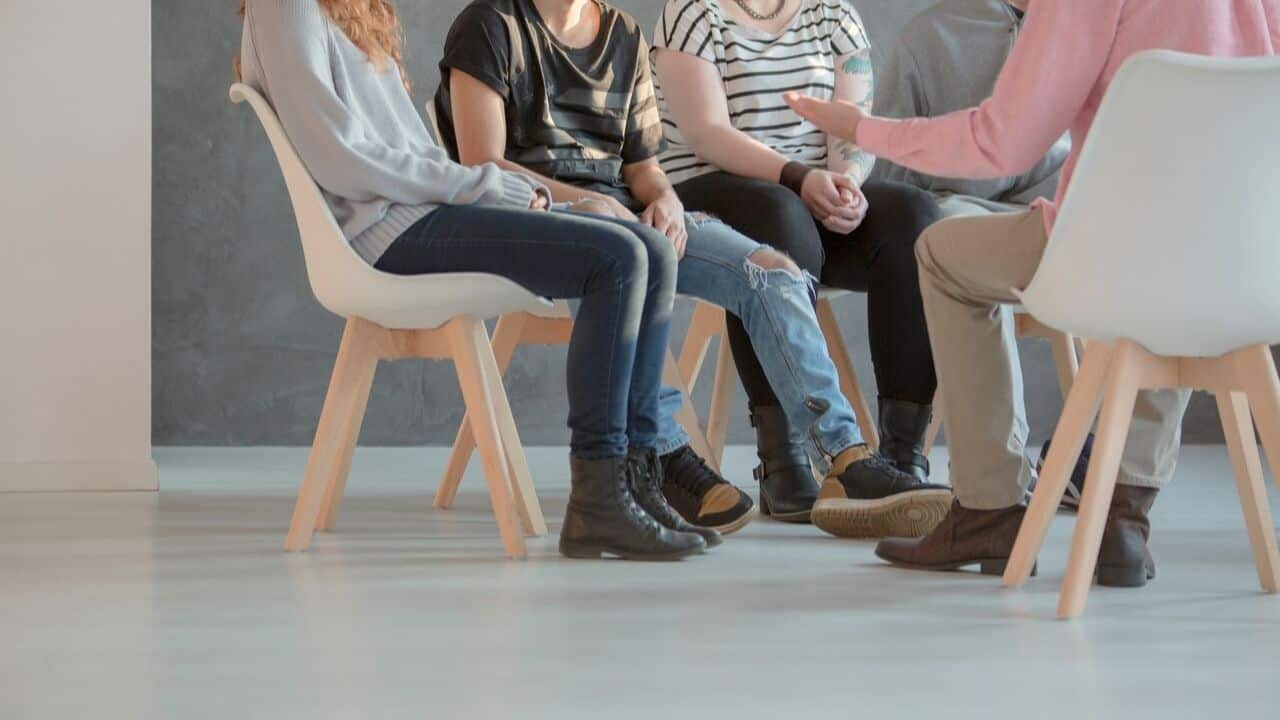 Support group gathering with individuals sharing experiences