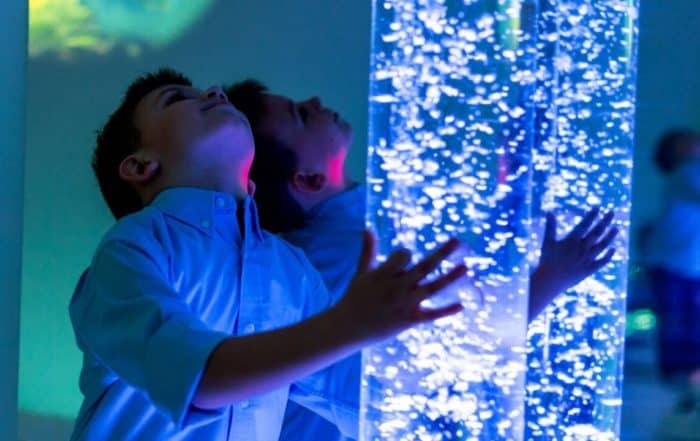 Child looking up while touching bubble colbs