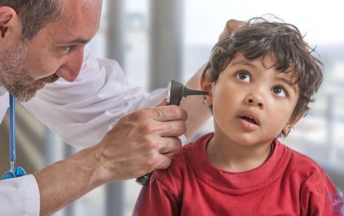 Doctor performing an ear checkup on a child