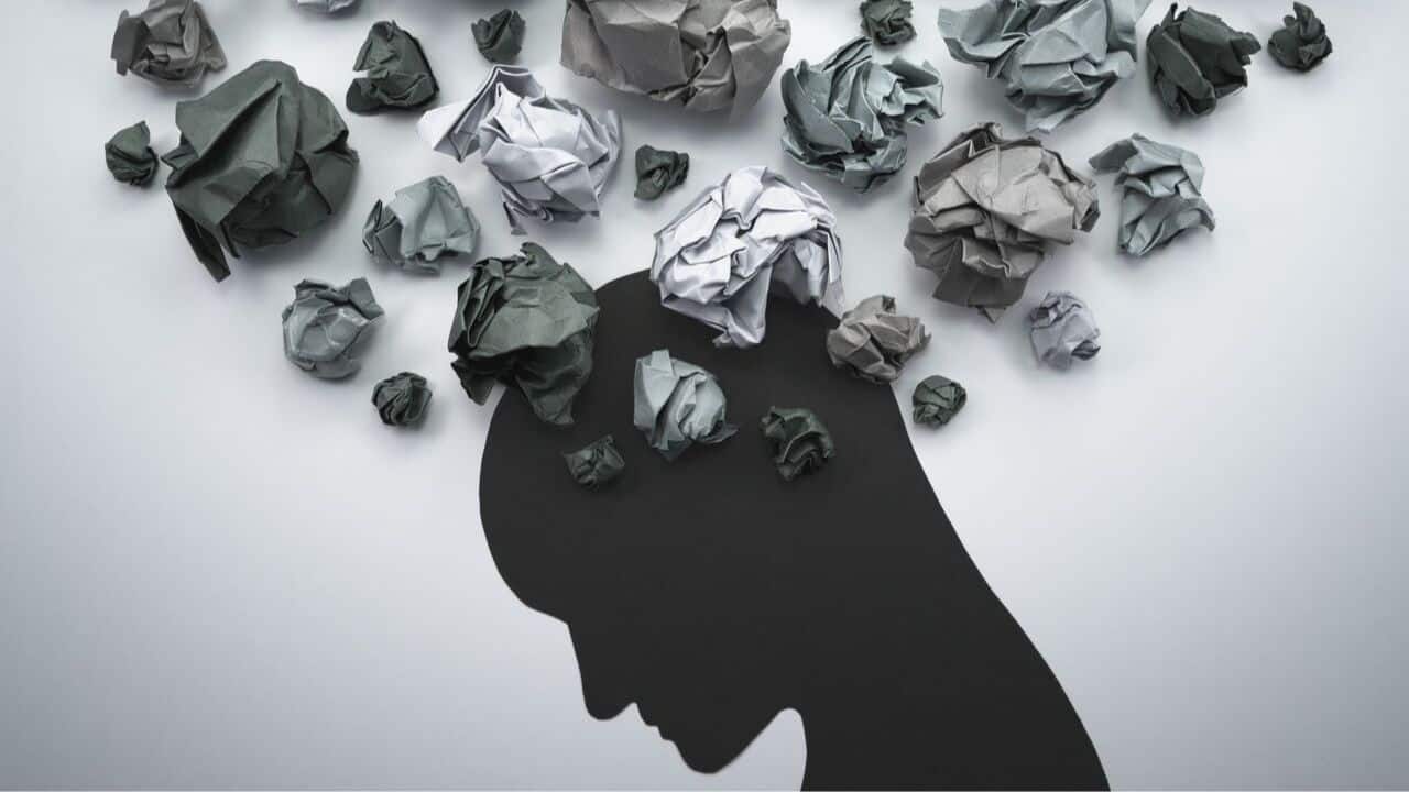Illustration of a man's head surrounded by scattered, crumpled papers, symbolizing stress or overwhelmed thoughts