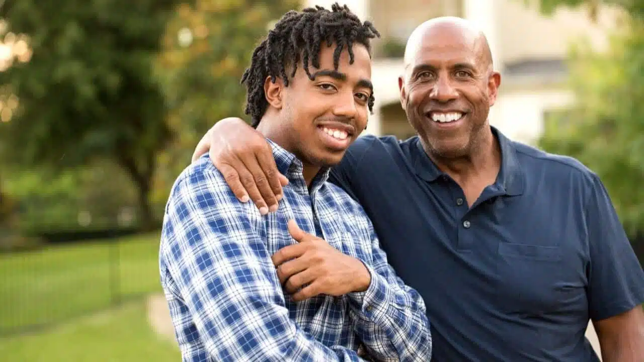 Two men hugging and smiling