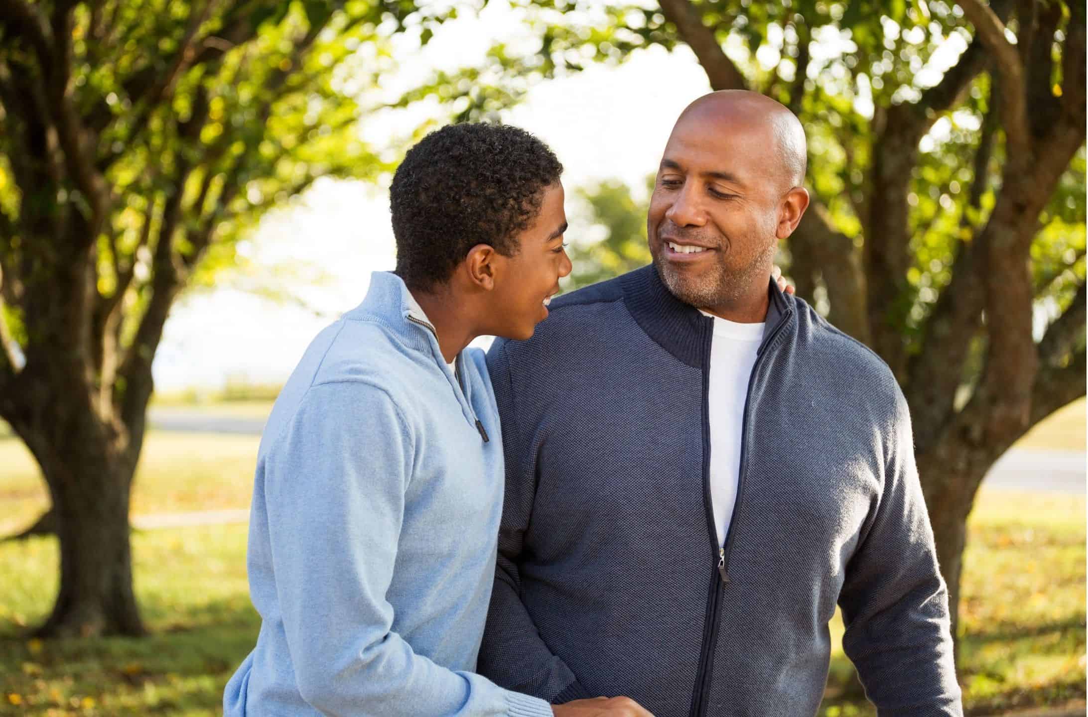 Untitled design (38) Father and son sharing a joyful moment, smiling and talking