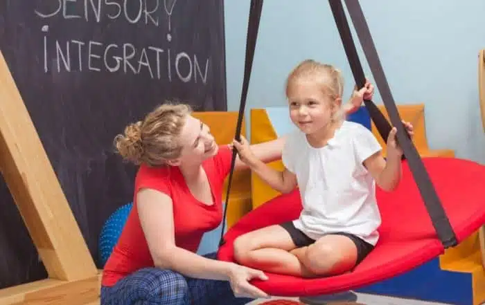 Child and therapist engaging in exercises in a sensory integration room