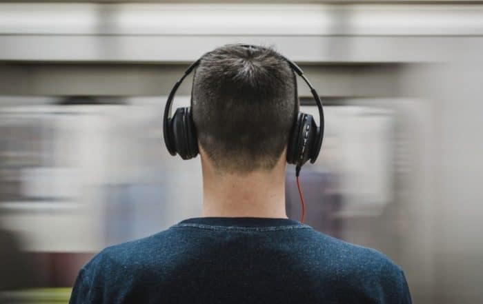 Young man standing with headphones on