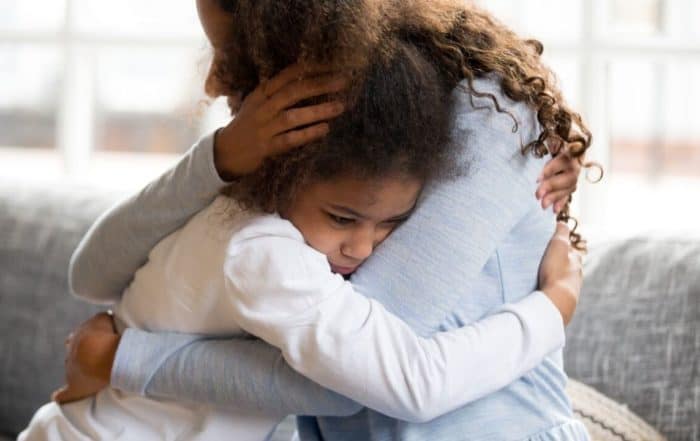 Child feeling anxious, embracing her mother