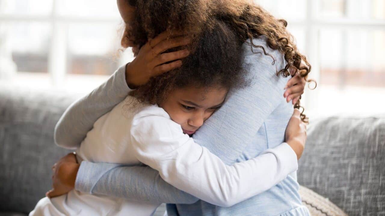 Child feeling anxious, embracing her mother