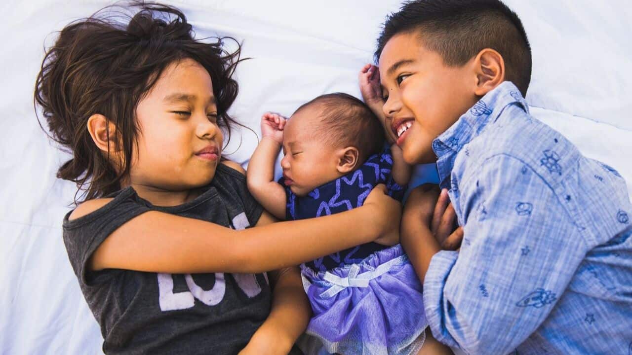 Three siblings hugging each other