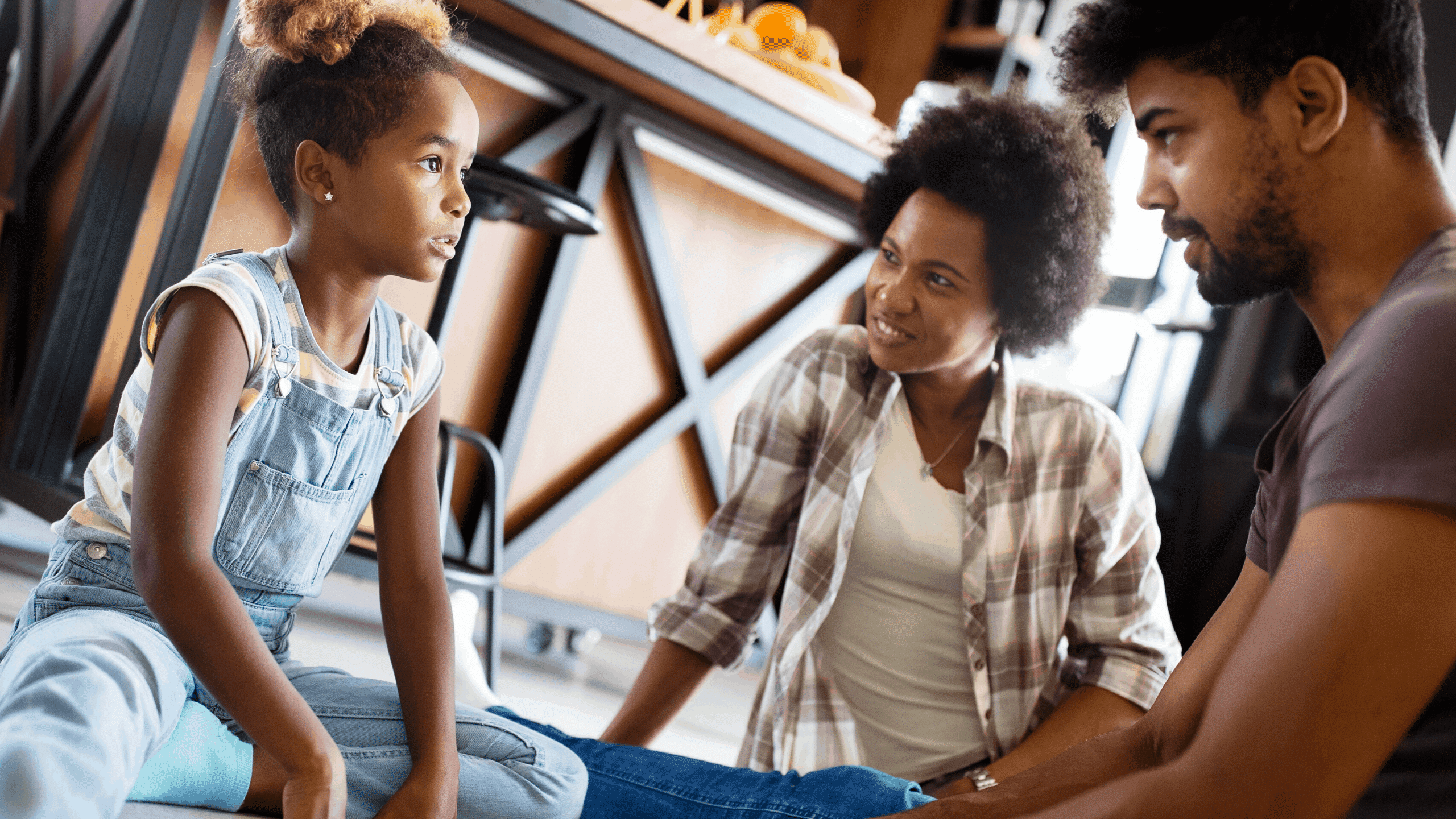 Child talking with parents while sitting on the kitchen floor