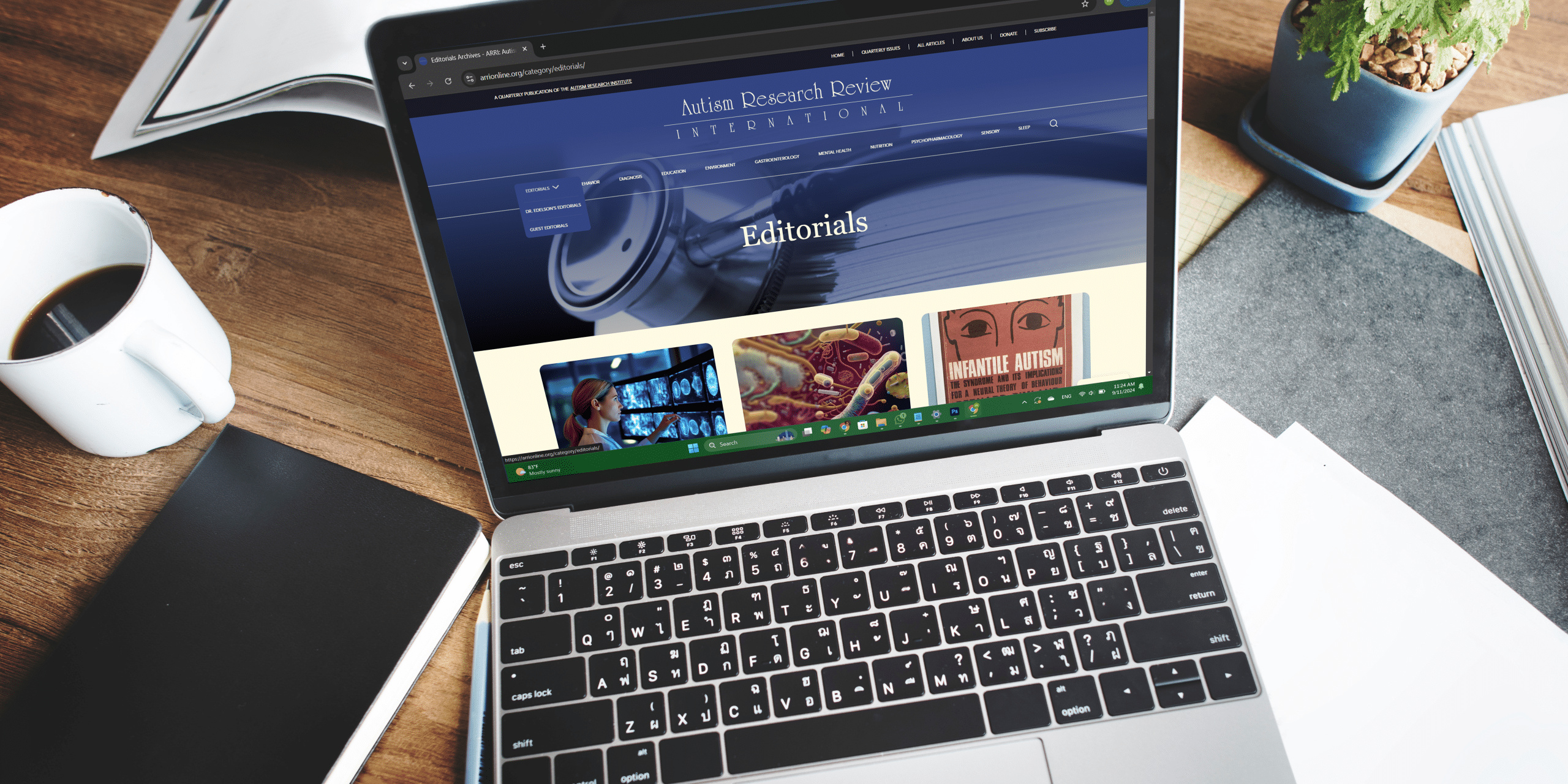 arri editorial page Work desk setup featuring a laptop, coffee cup, notebook, and potted plant