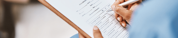 Person filling out a form on a clip board
